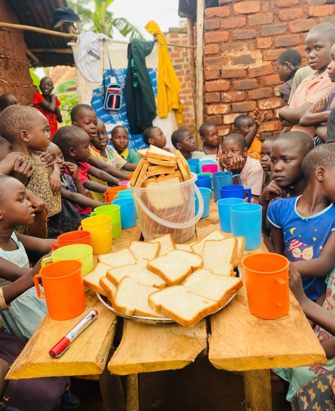 Children sharing bread and community at Kwaja Uganda